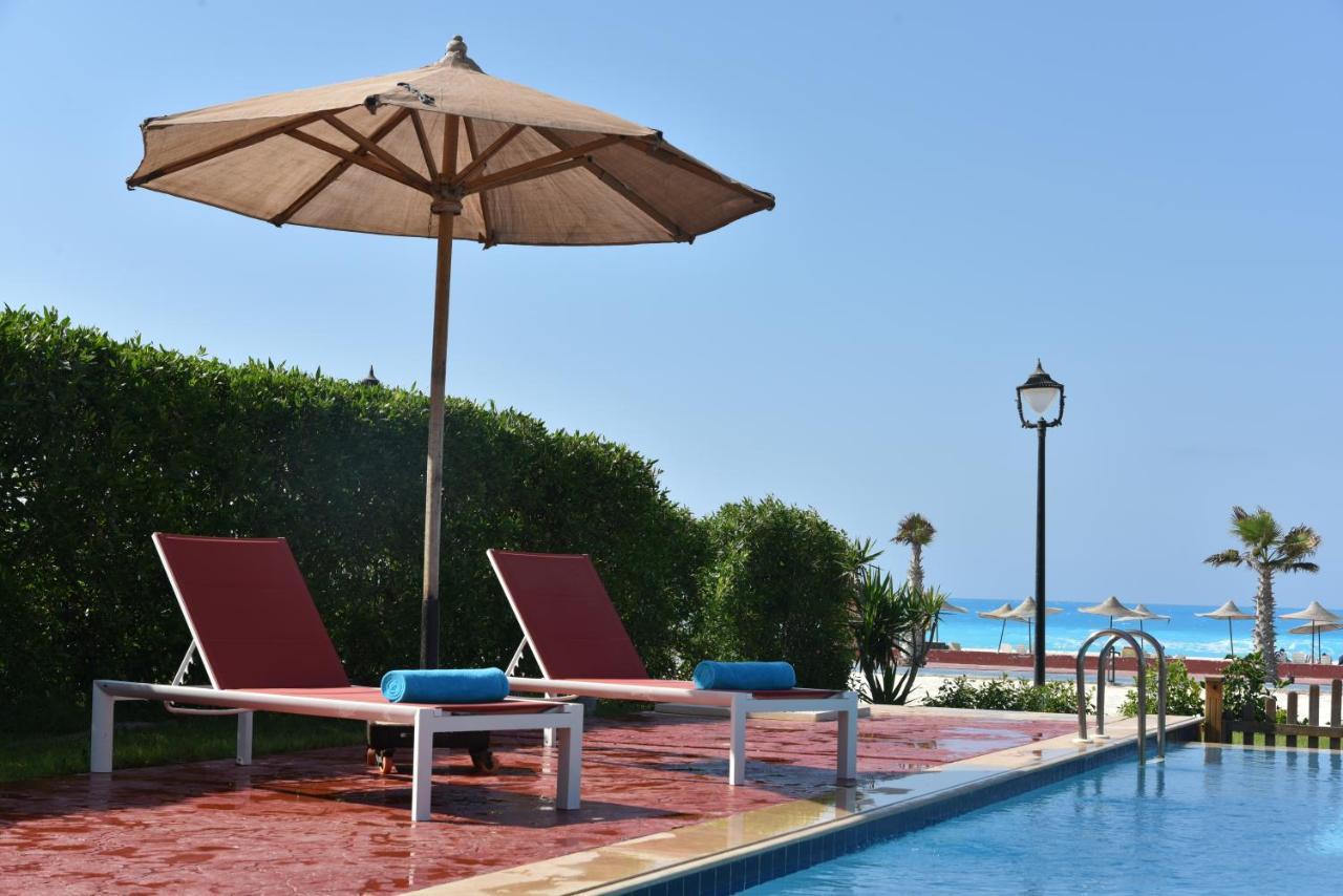 Tolip North Coast Hotel El Alamein Exterior photo A poolside umbrella